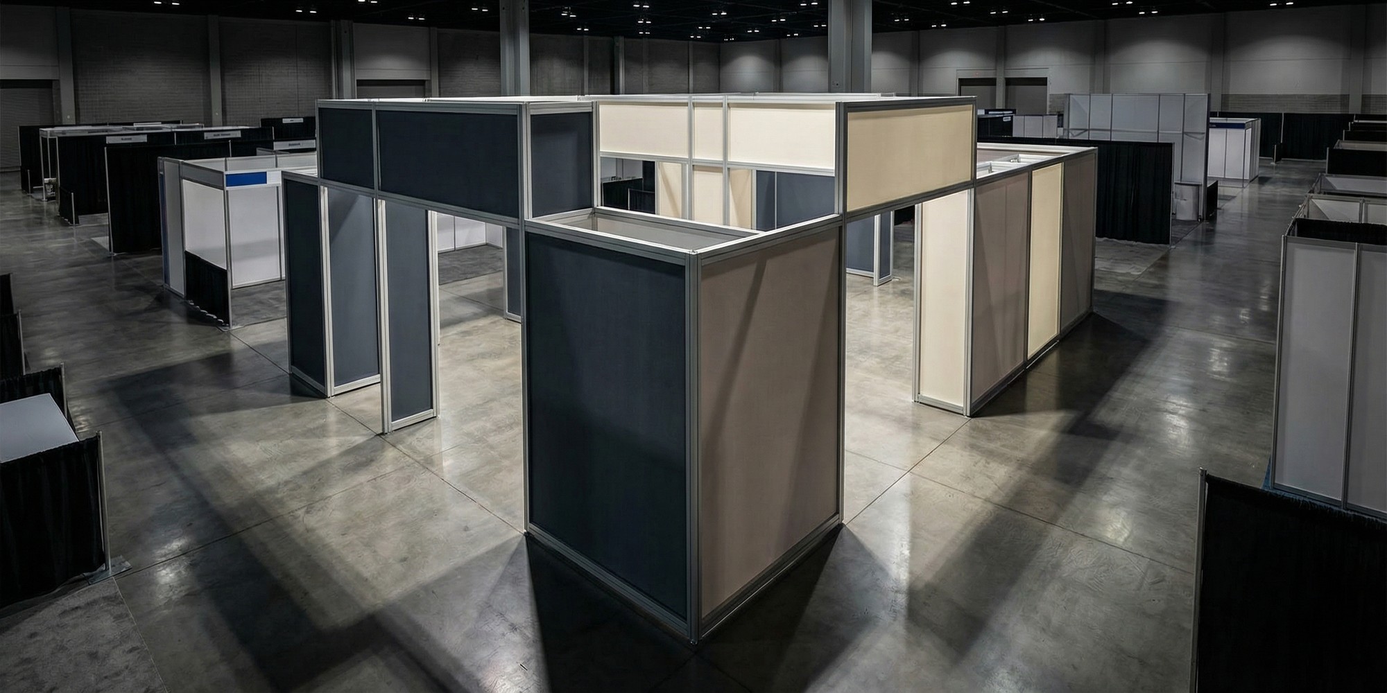 Modular rental trade show exhibit system with aluminum extrusion frames and backlit fabric panels in a convention hall